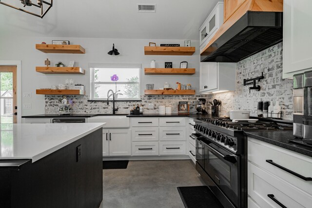 kitchen with visible vents, open shelves, double oven range, exhaust hood, and a sink