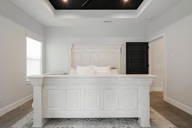 bedroom with visible vents, a raised ceiling, and baseboards