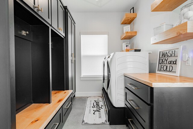 clothes washing area featuring cabinet space, separate washer and dryer, and baseboards