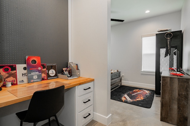 office with finished concrete floors, recessed lighting, baseboards, and built in study area