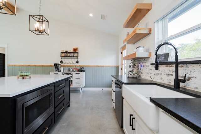 kitchen with dishwashing machine, open shelves, concrete flooring, stainless steel microwave, and dark cabinets