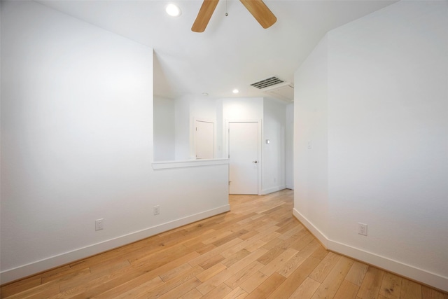 empty room with ceiling fan and light hardwood / wood-style floors