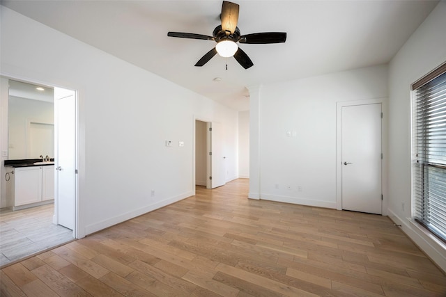 unfurnished bedroom featuring ceiling fan, sink, and light hardwood / wood-style floors