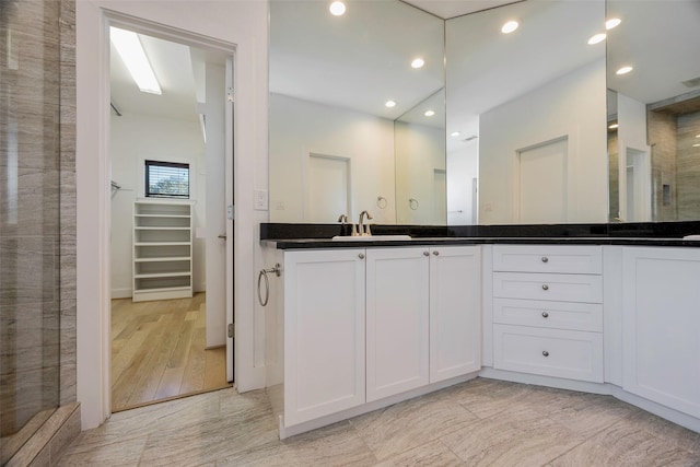 bathroom with vanity and a shower