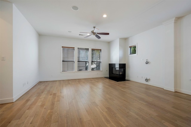 unfurnished living room with light hardwood / wood-style flooring, ceiling fan, and a multi sided fireplace