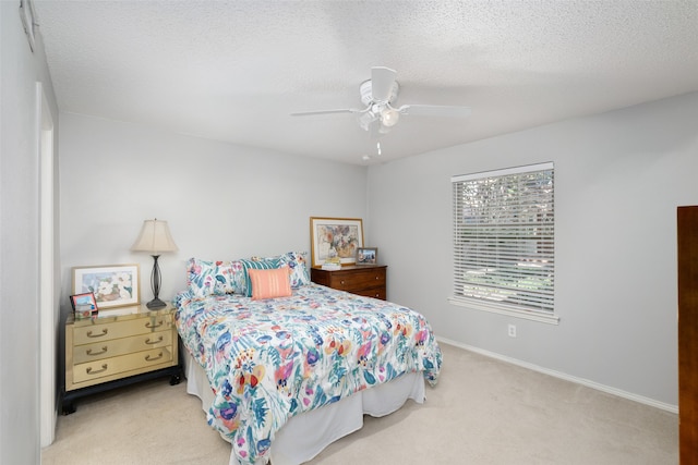 carpeted bedroom with ceiling fan and a textured ceiling