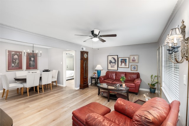 living room with ceiling fan with notable chandelier, light wood-type flooring, and ornamental molding