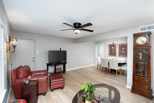 living room featuring ceiling fan with notable chandelier, light hardwood / wood-style floors, and ornamental molding