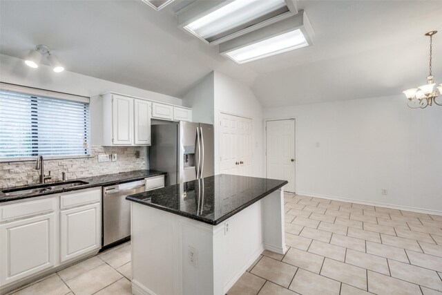 kitchen featuring stainless steel appliances, lofted ceiling, a kitchen island, white cabinets, and sink