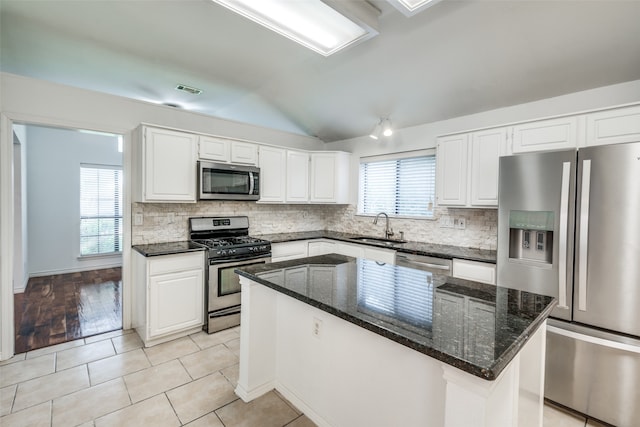 kitchen featuring a center island, stainless steel appliances, light tile patterned floors, white cabinets, and sink