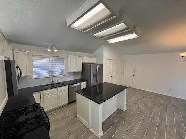 kitchen with sink, white cabinetry, an inviting chandelier, a center island, and appliances with stainless steel finishes