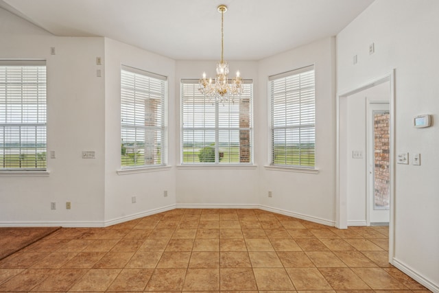 unfurnished dining area with a wealth of natural light, light tile patterned floors, and an inviting chandelier