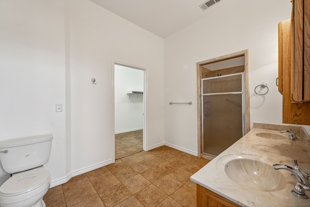 bathroom featuring tile patterned floors, a shower with door, vanity, and toilet