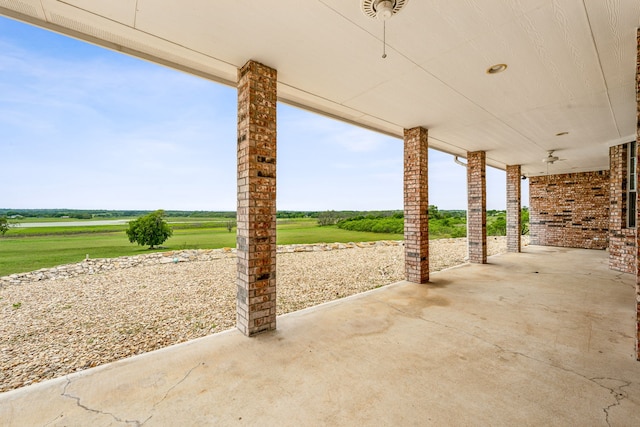 view of patio with ceiling fan and a rural view