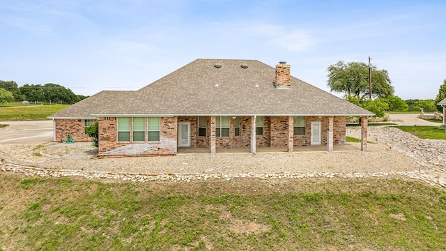 back of property featuring a yard and covered porch