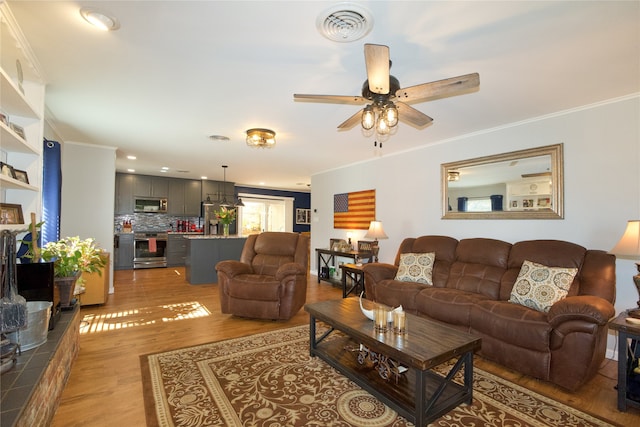 living room with ceiling fan, light hardwood / wood-style floors, and crown molding