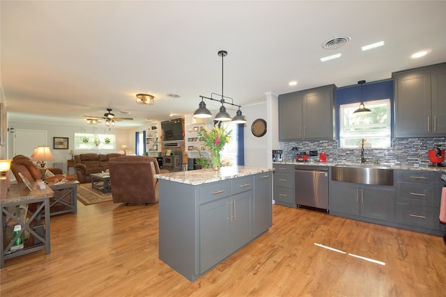 kitchen featuring dishwasher, light hardwood / wood-style flooring, a kitchen island, and sink