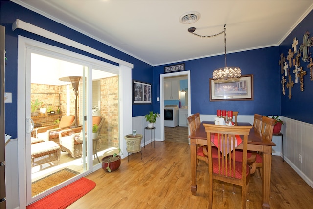 dining area featuring hardwood / wood-style flooring, separate washer and dryer, and crown molding