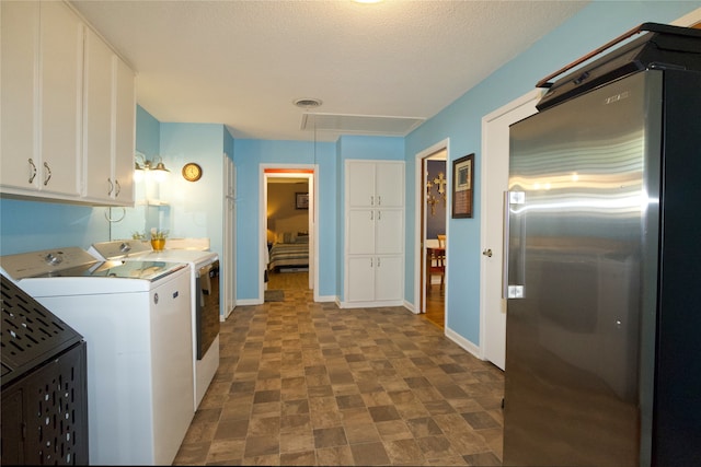 washroom featuring washing machine and clothes dryer and a textured ceiling