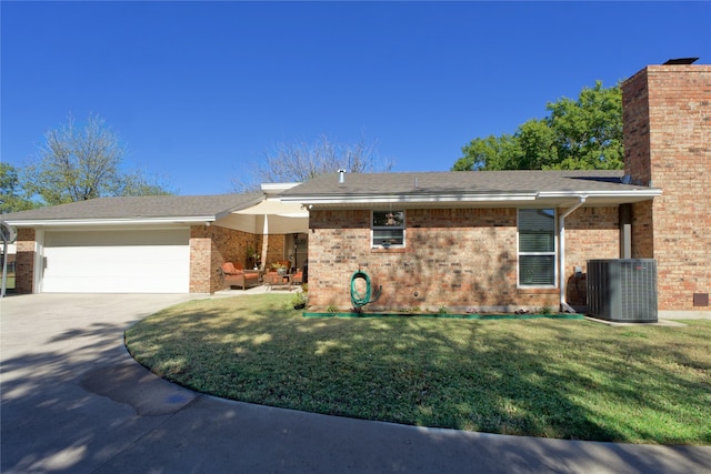 view of front of property with cooling unit, a garage, and a front yard