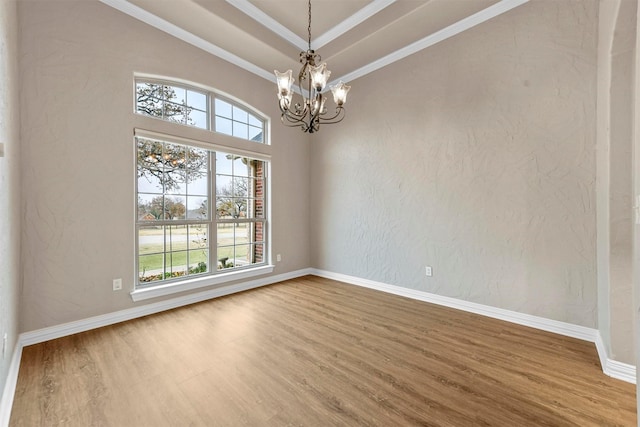 unfurnished room with hardwood / wood-style floors, crown molding, and a notable chandelier