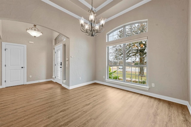 spare room with a chandelier, light hardwood / wood-style floors, and ornamental molding