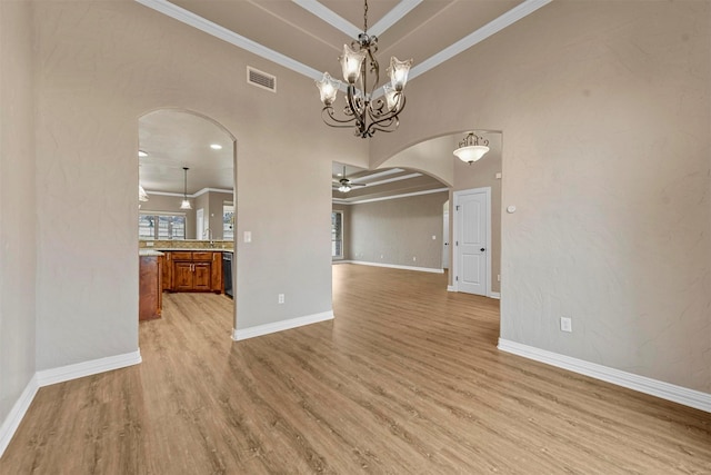 unfurnished dining area with ceiling fan with notable chandelier, light hardwood / wood-style flooring, and crown molding