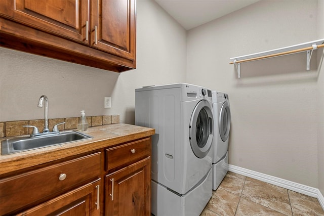 laundry room with cabinets, washing machine and dryer, light tile patterned flooring, and sink