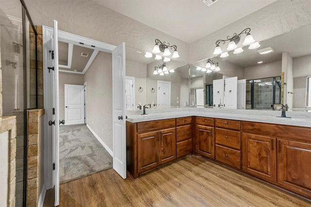 bathroom with a chandelier, a shower with door, vanity, and wood-type flooring