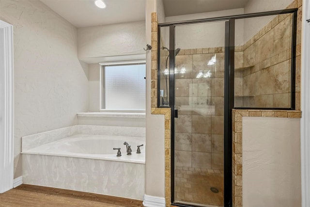 bathroom featuring hardwood / wood-style flooring and separate shower and tub