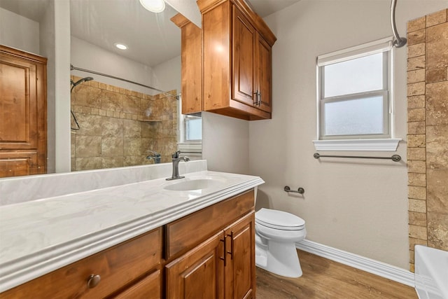 bathroom with toilet, vanity, and hardwood / wood-style flooring