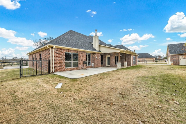 rear view of house featuring a yard and a patio