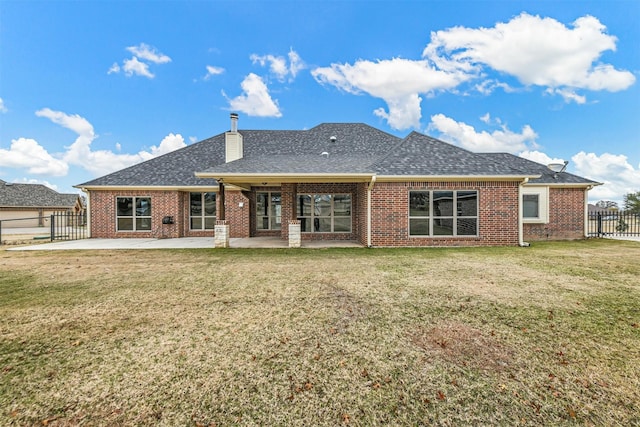 back of house with a patio and a lawn