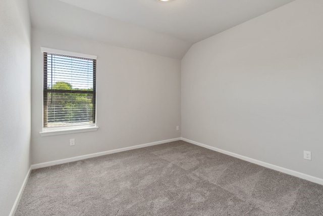 carpeted spare room with lofted ceiling