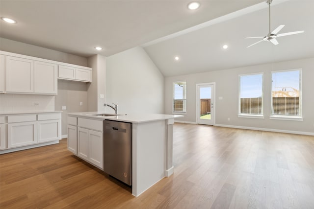 kitchen with stainless steel dishwasher, vaulted ceiling, a kitchen island with sink, white cabinets, and light hardwood / wood-style floors