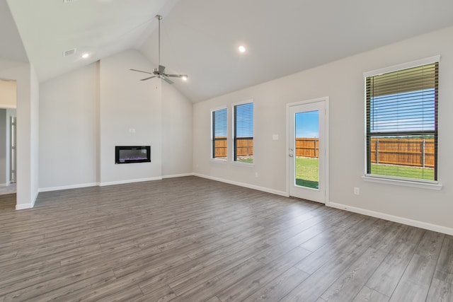 unfurnished living room featuring a wealth of natural light, ceiling fan, and light hardwood / wood-style floors