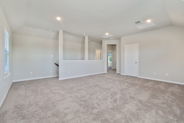 empty room with light colored carpet and lofted ceiling