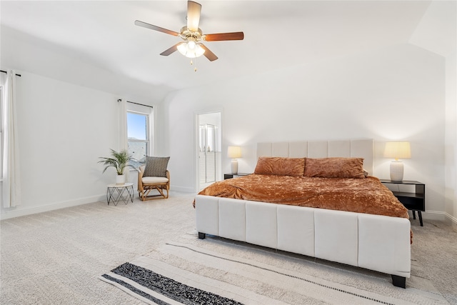 bedroom featuring ensuite bath, ceiling fan, light carpet, and vaulted ceiling