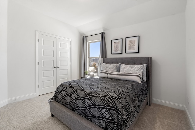 bedroom with carpet flooring, a closet, and lofted ceiling