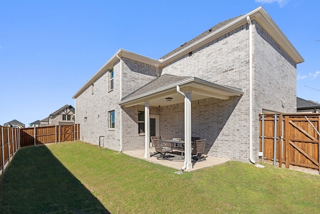 rear view of house with a lawn and a patio area