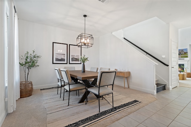 dining area with light tile patterned floors and an inviting chandelier