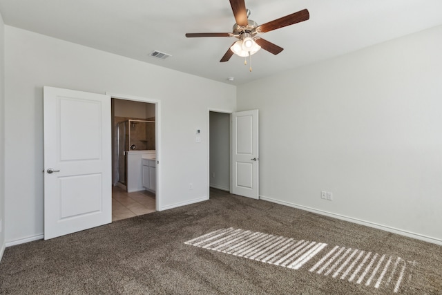 unfurnished bedroom featuring light colored carpet, ensuite bath, and ceiling fan