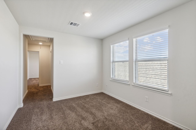 spare room featuring dark carpet