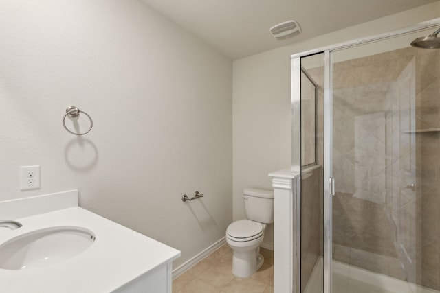 bathroom featuring tile patterned floors, vanity, toilet, and a shower with door