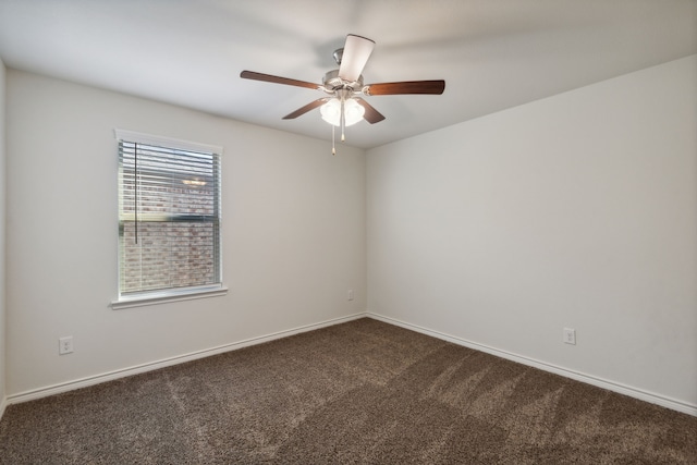 spare room featuring ceiling fan and dark carpet