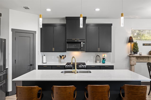 kitchen with a center island with sink, pendant lighting, and sink