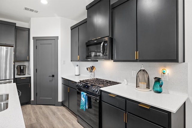 929 Cope St, Mansfield, TX 76065 - kitchen featuring stainless steel appliances, light wood-style flooring, and dark cabinetry