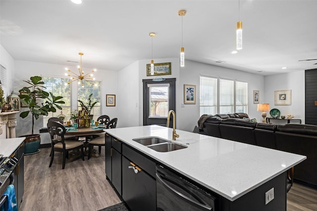 kitchen with sink, an island with sink, hanging light fixtures, and plenty of natural light