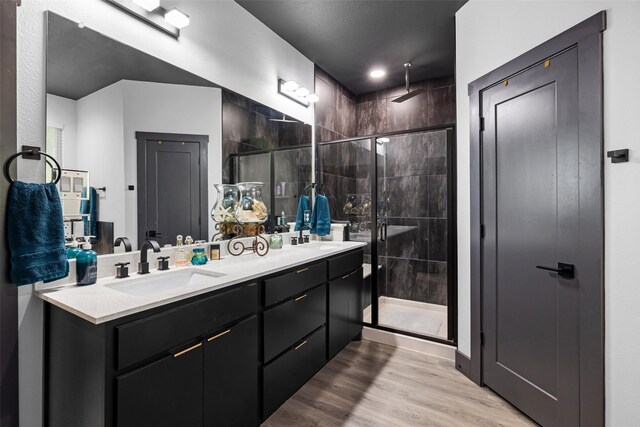 bathroom featuring hardwood / wood-style floors, vanity, and a shower with door