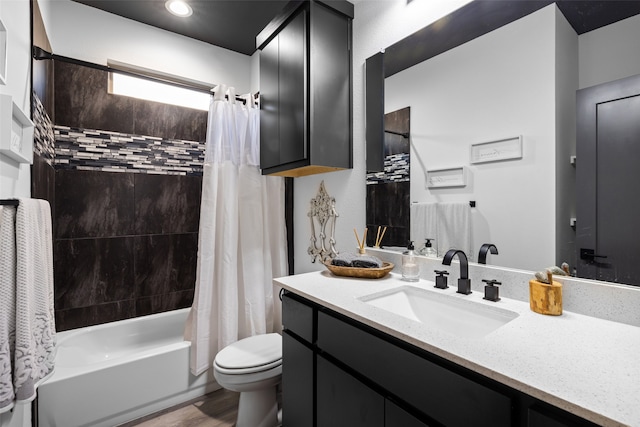 full bathroom with hardwood / wood-style floors, vanity, shower / bath combo, and toilet